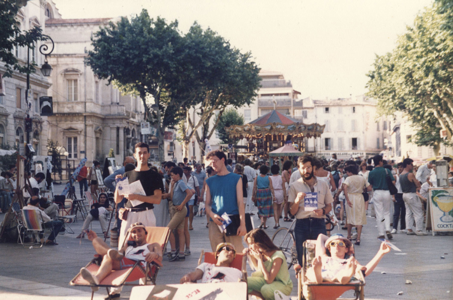 Ambiente de festival en una plaza con carrusel y viandantes